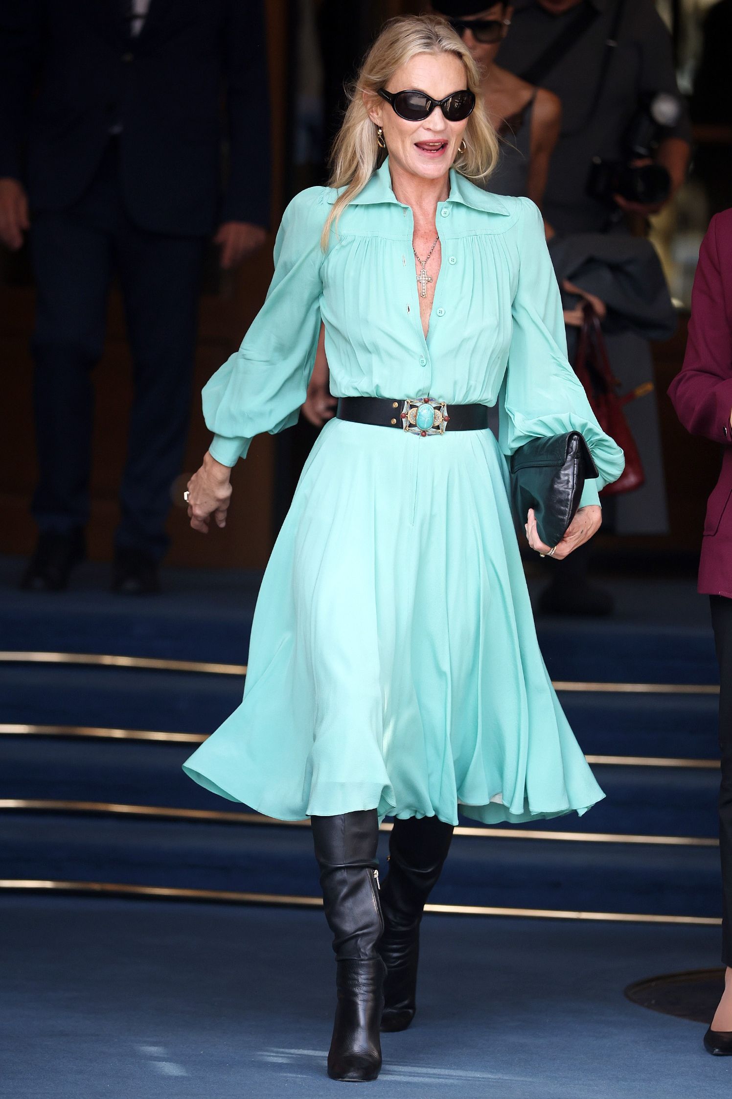 Kate Moss wearing turquoise midi dress and black knee high boots for Day Two of Paris Fashion Week on September 29, 2026 in Paris, France