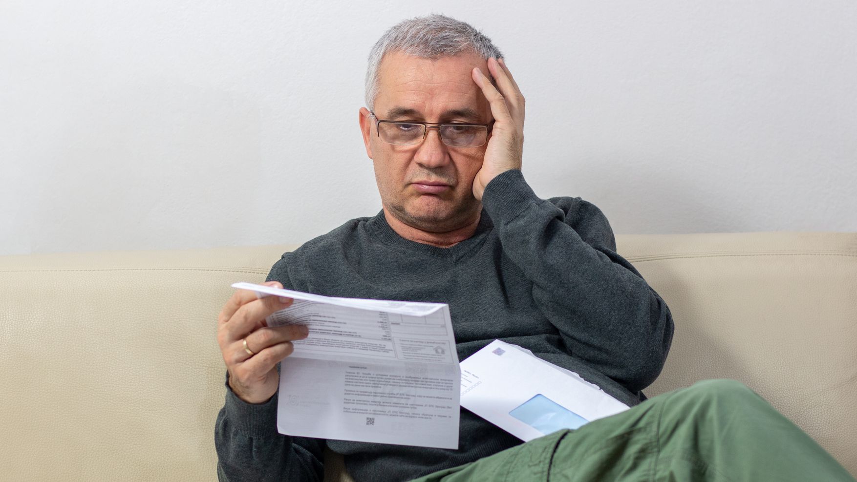 Man reading unexpected news in his mail.