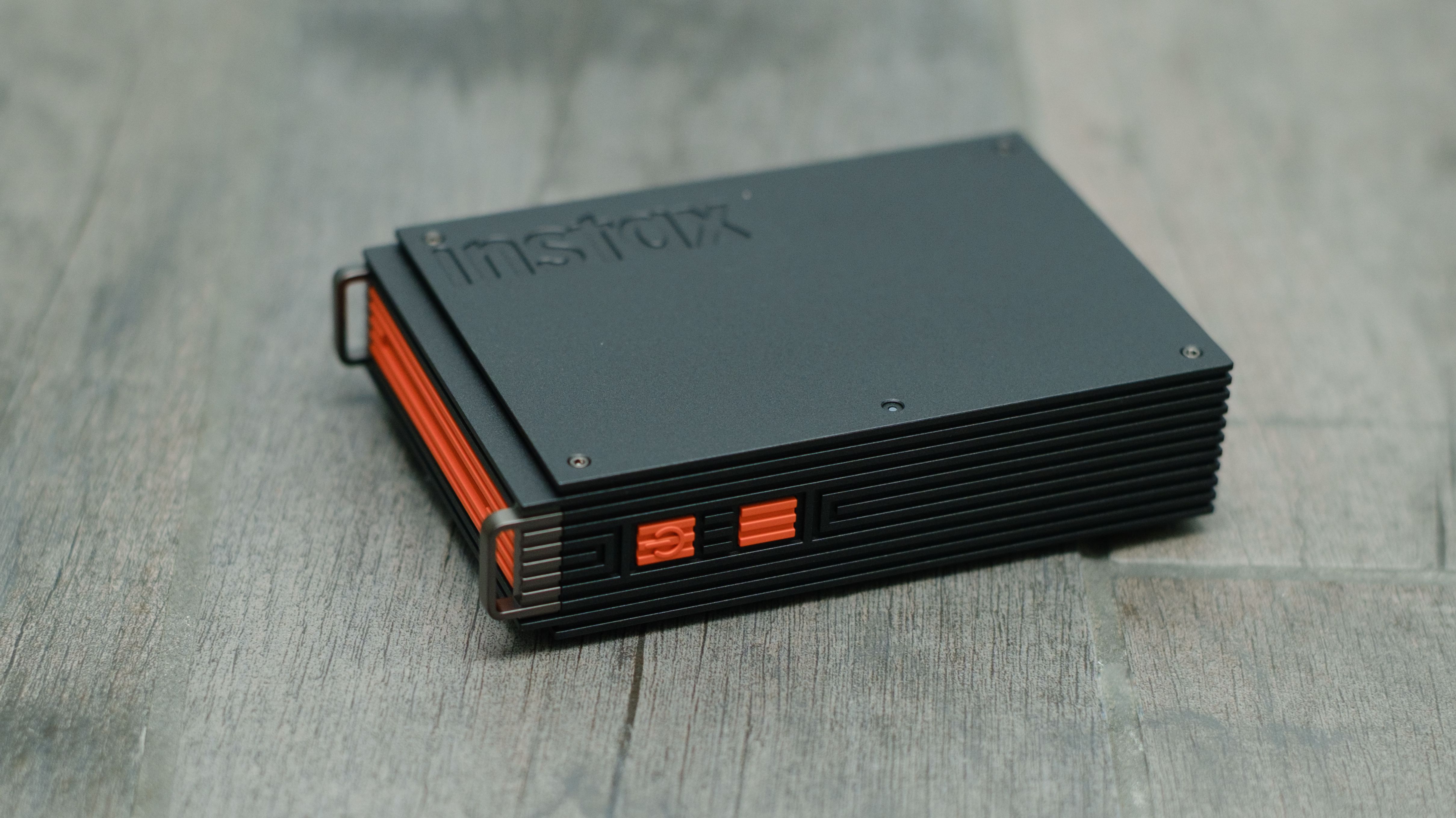 The Fujifilm Instax Mini Link+ on a gray background with instant prints