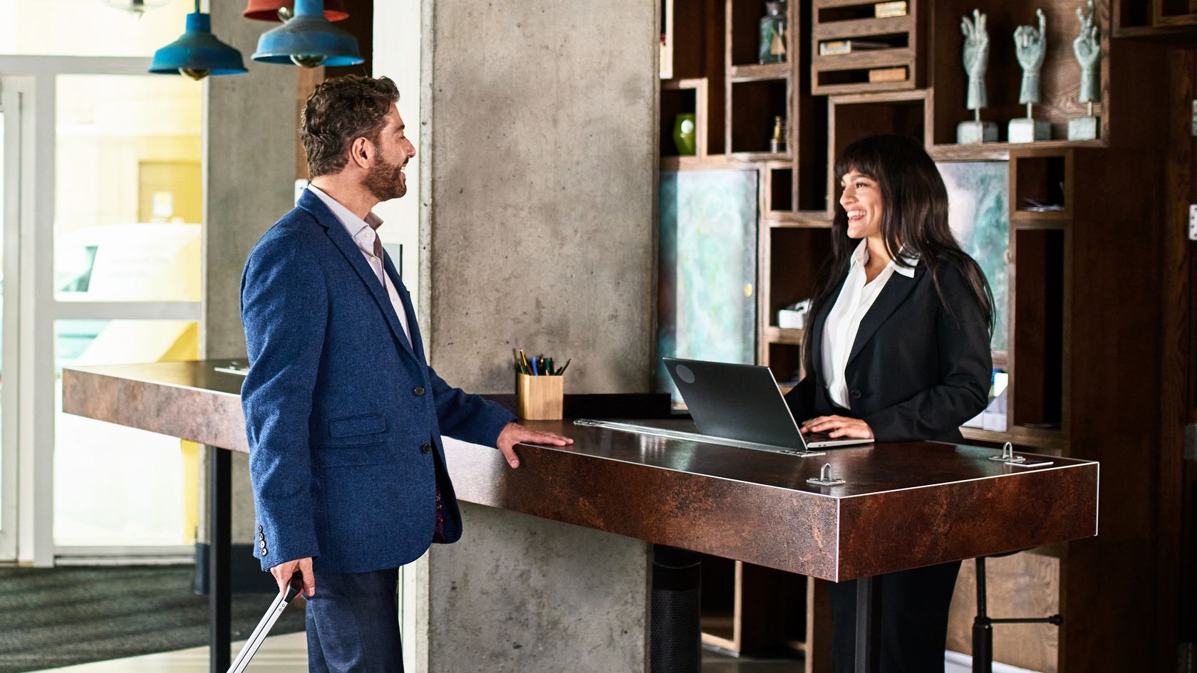 Businessman with suitcase arriving at hotel reception