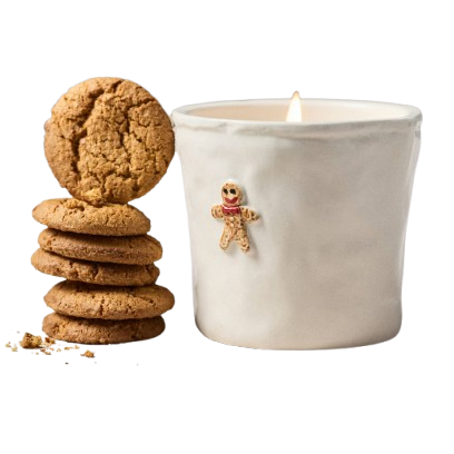 A gingerbread candle with gingerbread cookies stacked beside it