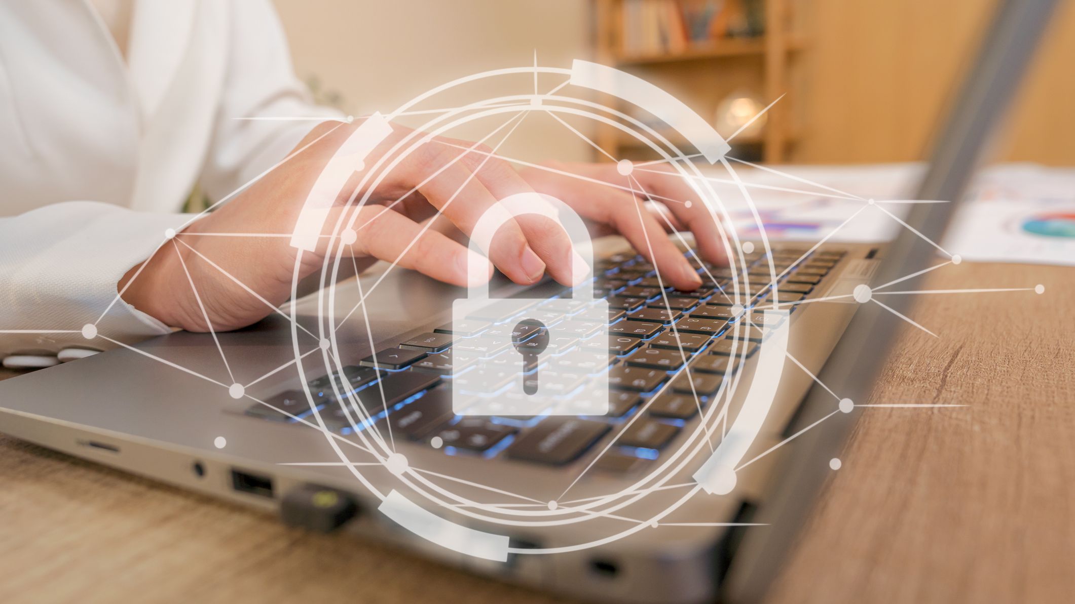 A person's hands typing on a laptop with a digital security padlock symbol overlaid.