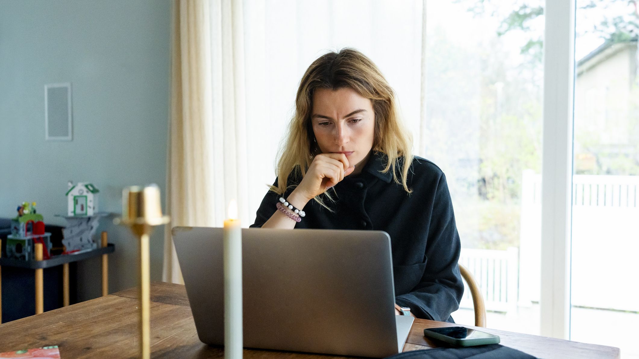 A woman looking concerned while working on her laptop