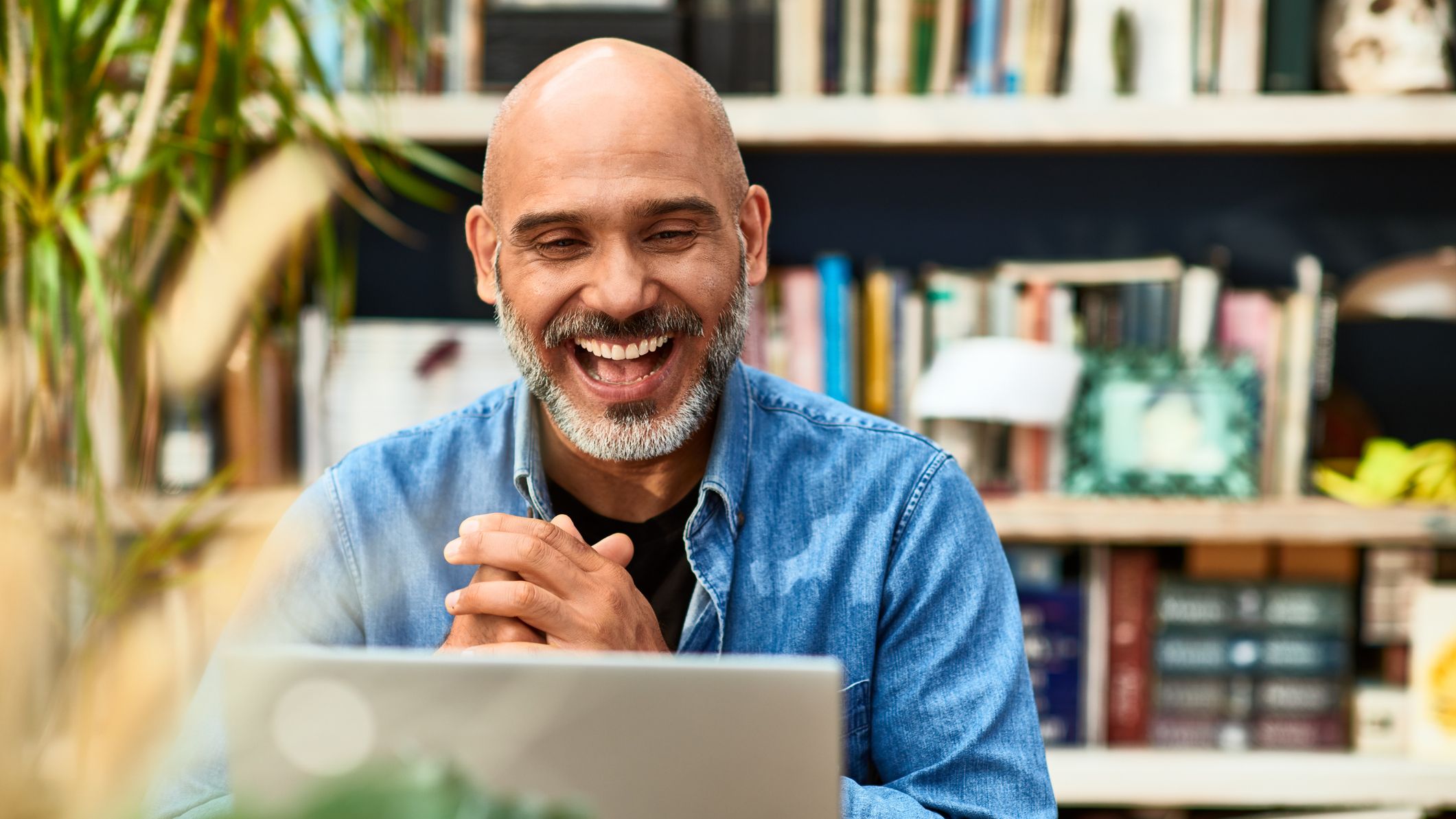 a man smiling while looking at his computer