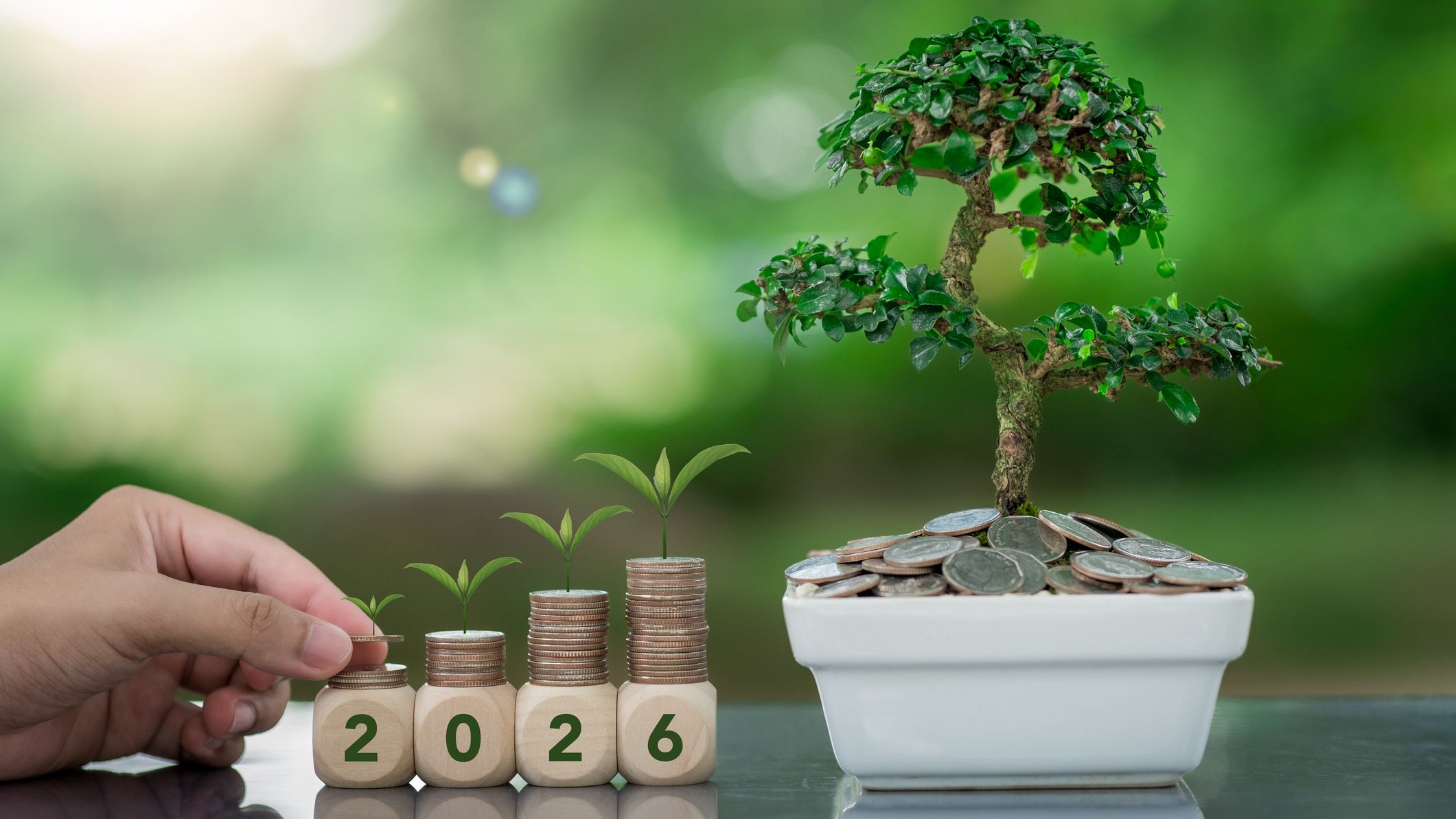 2026 in scrabble tiles next to a bonzai tree and stacks of coins