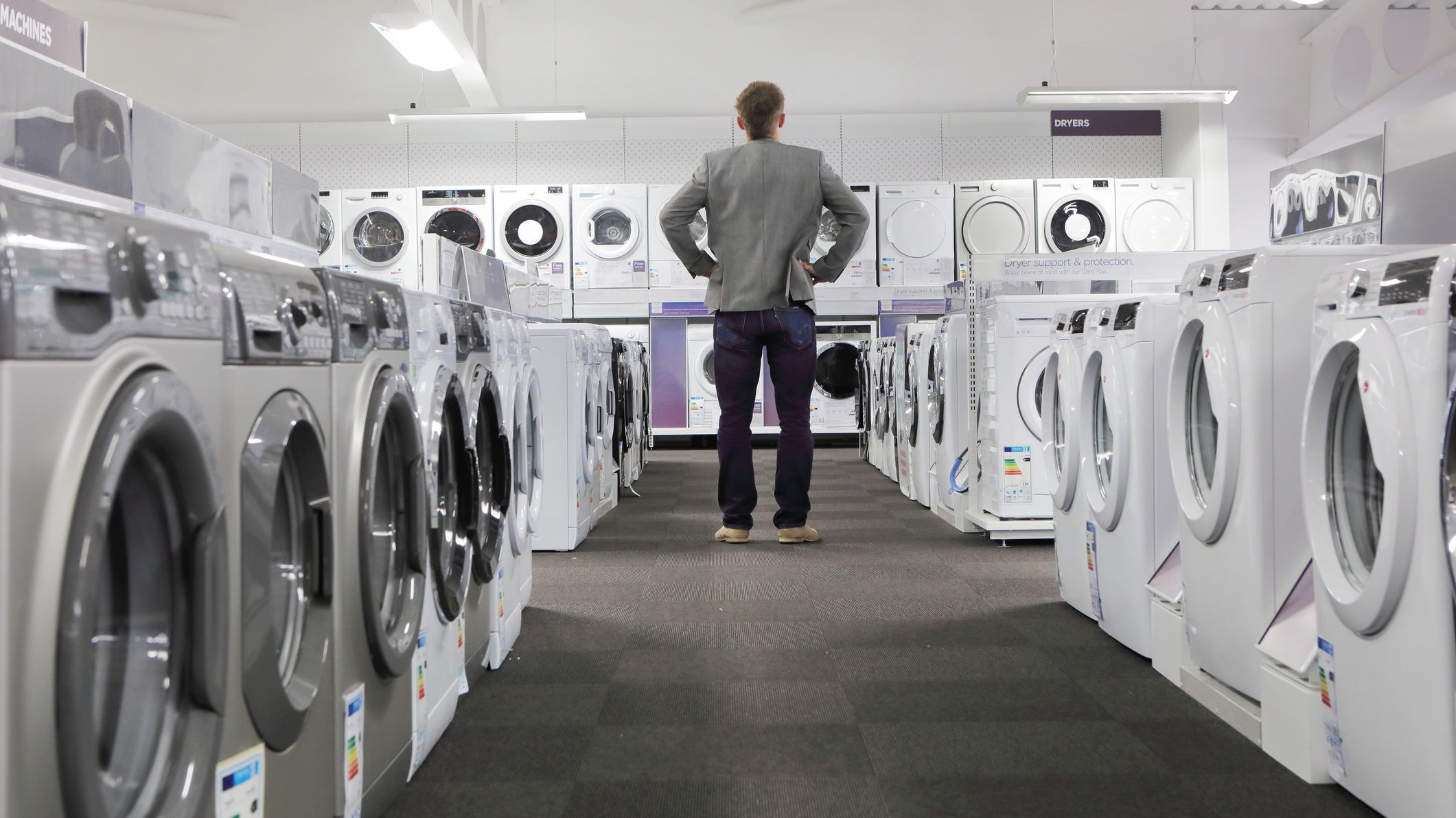 Man looking at washing machines and dryers in a store