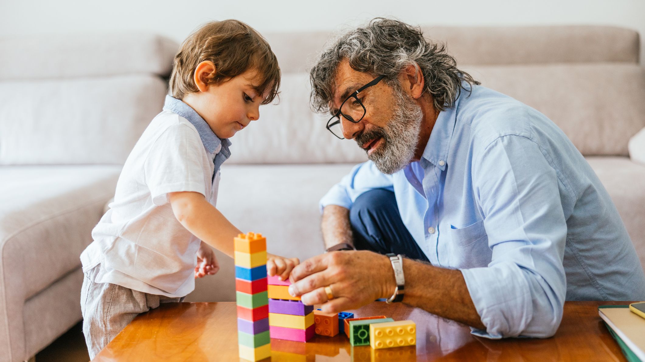 Grandfather with his grandson playing with legos