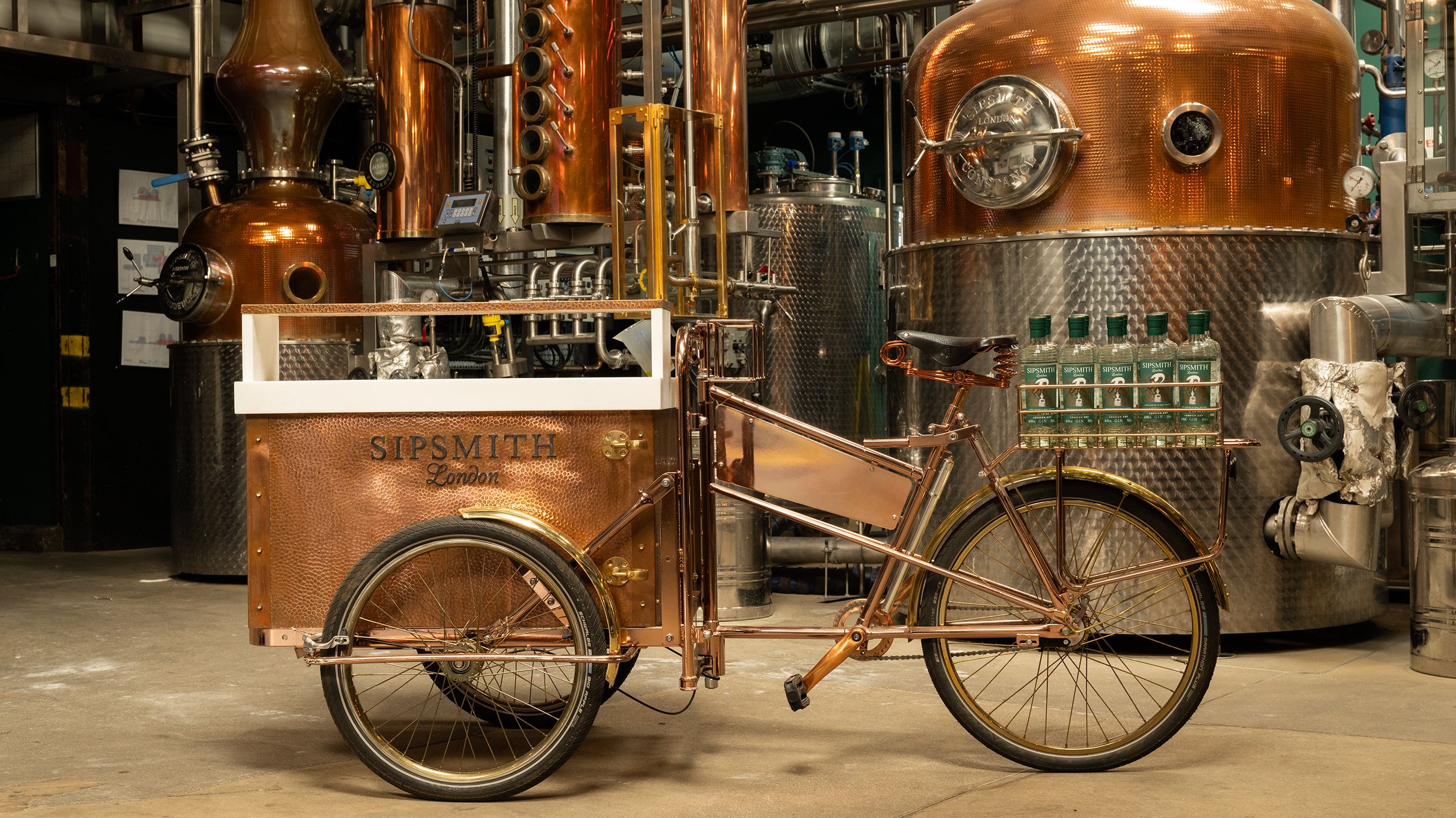 an image of a vintage-style bike with a bronze Sipsmith cooler attached to the front, ready to serve g&amp;amp;ts on the go