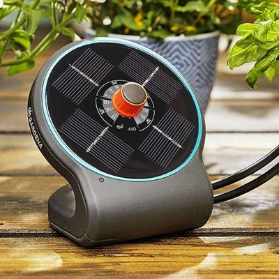 Gardena garden watering system on a wooden table in front of potted plants