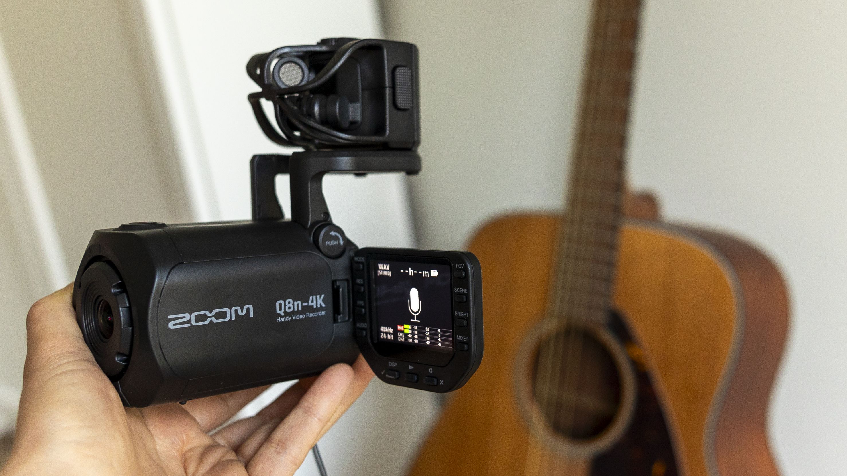 The Zoom Q8n-4K in front of a guitar