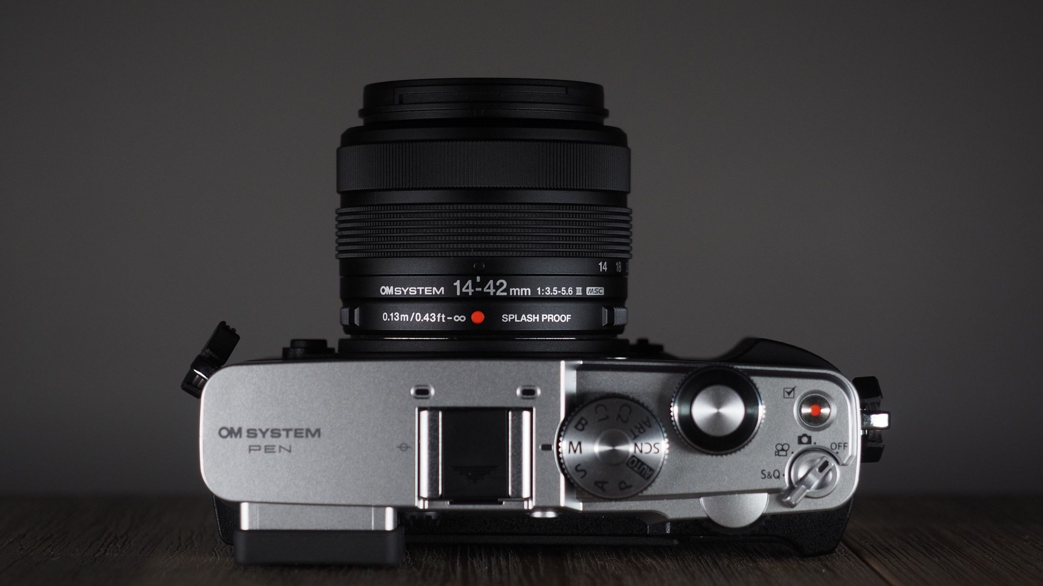 OM System OM-3 with the OM System M.Zuiko 14-42mm 3.5-5.6 III on a wooden surface