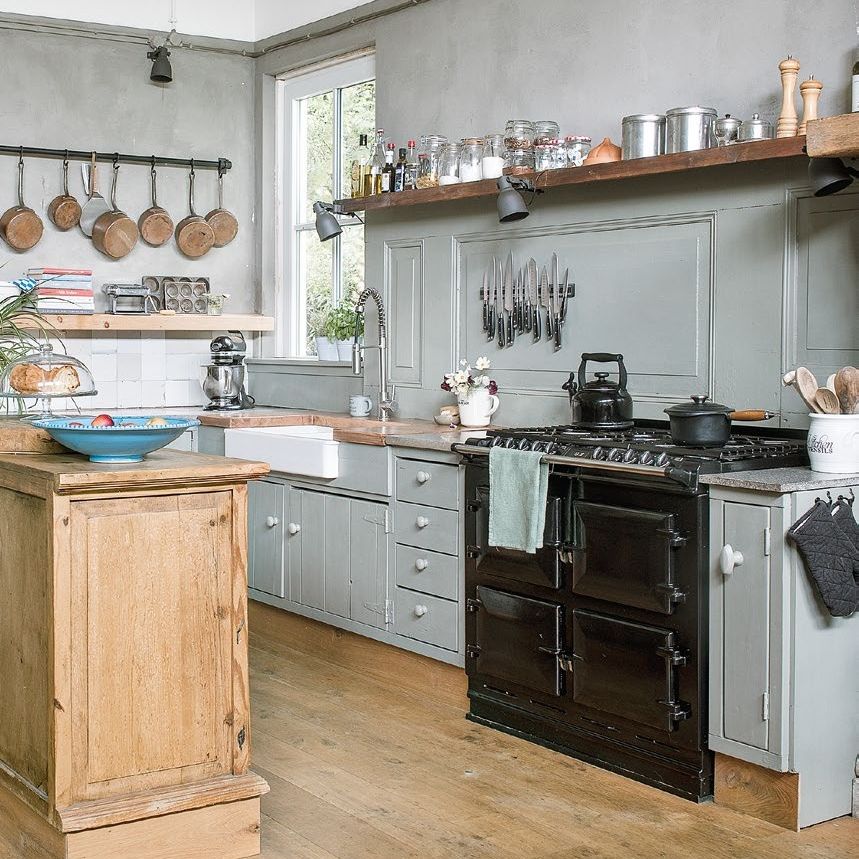 Industrial vintage style kitchen with sage green units, wooden island and black range cooker