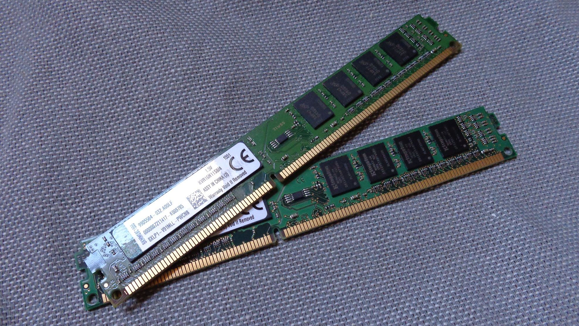 Two sticks of Kingston DDR3 RAM sitting on a textured blue/grey surface.
