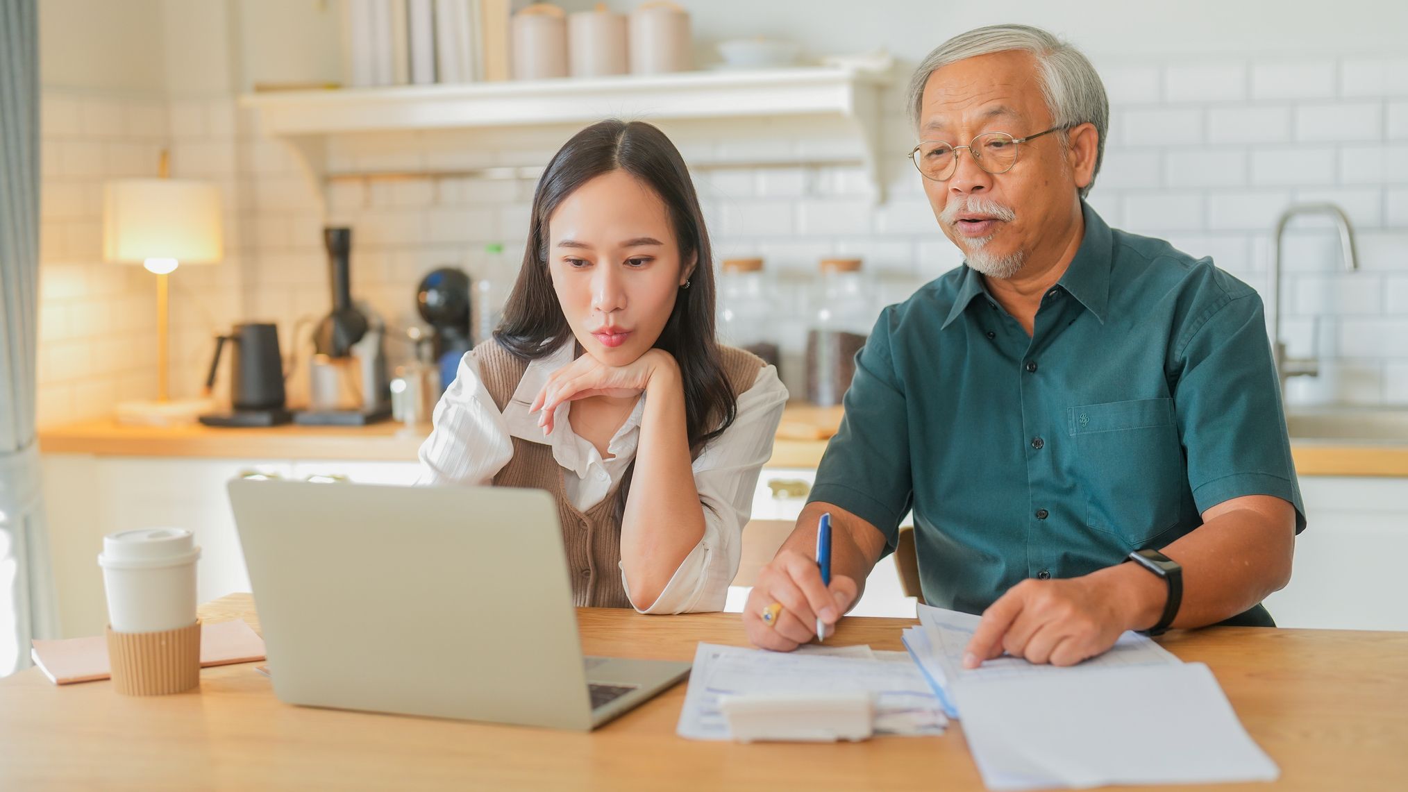 a father and daughter go over estate plans at their kitchen table