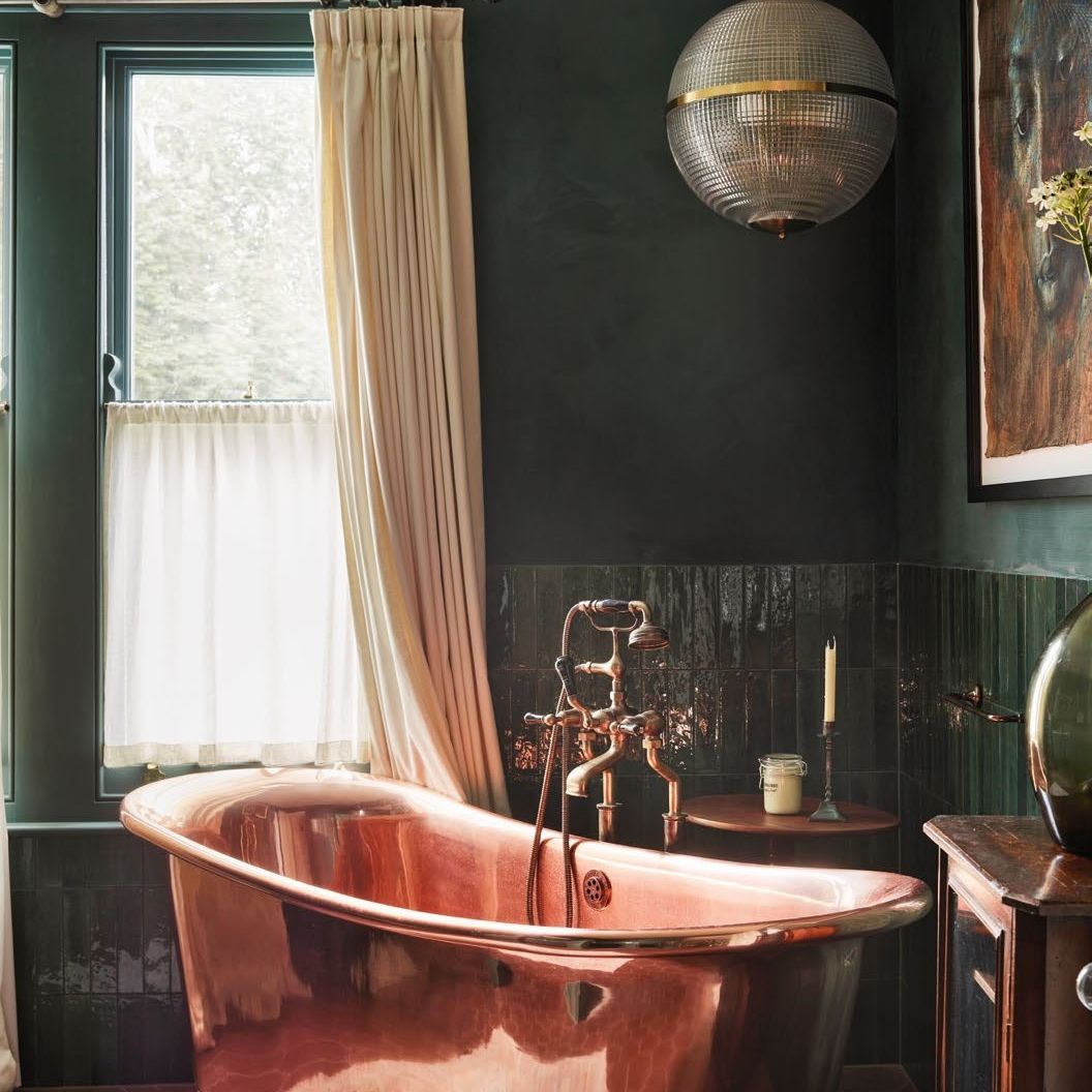 freestanding copper bath in a luxury style dark green bathroom