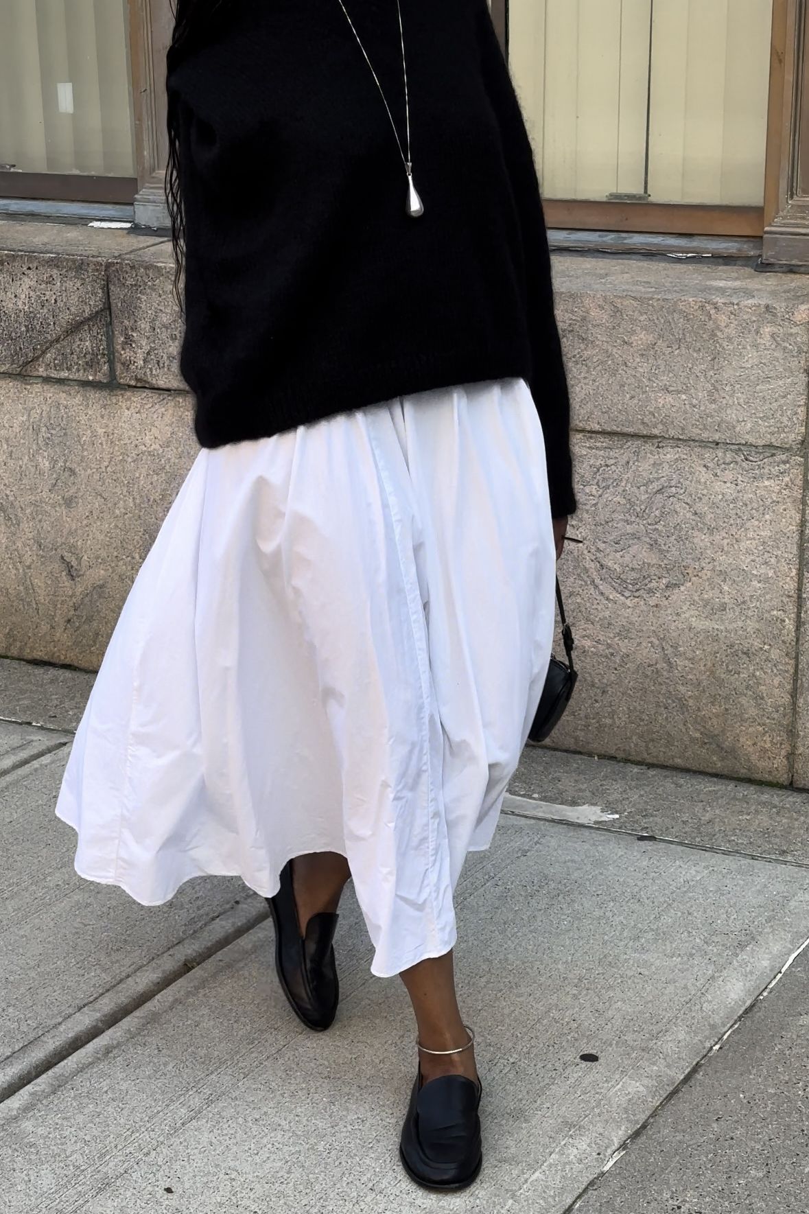 Maya Moore styles her everyday Vince loafers with a white cotton midi skirt and black sweater