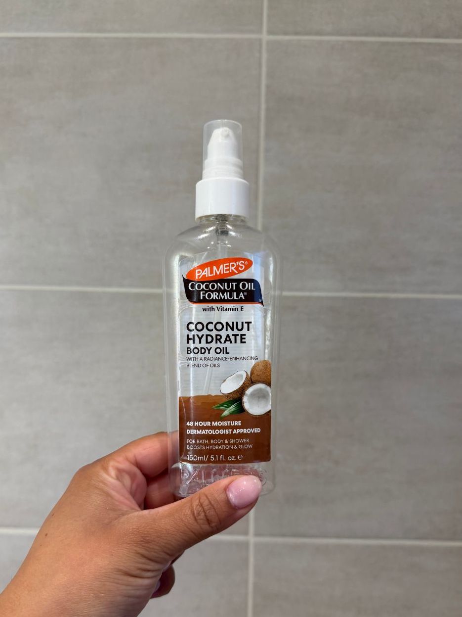 Aleesha holding empty Palmers Coconut Hydrate Oil
