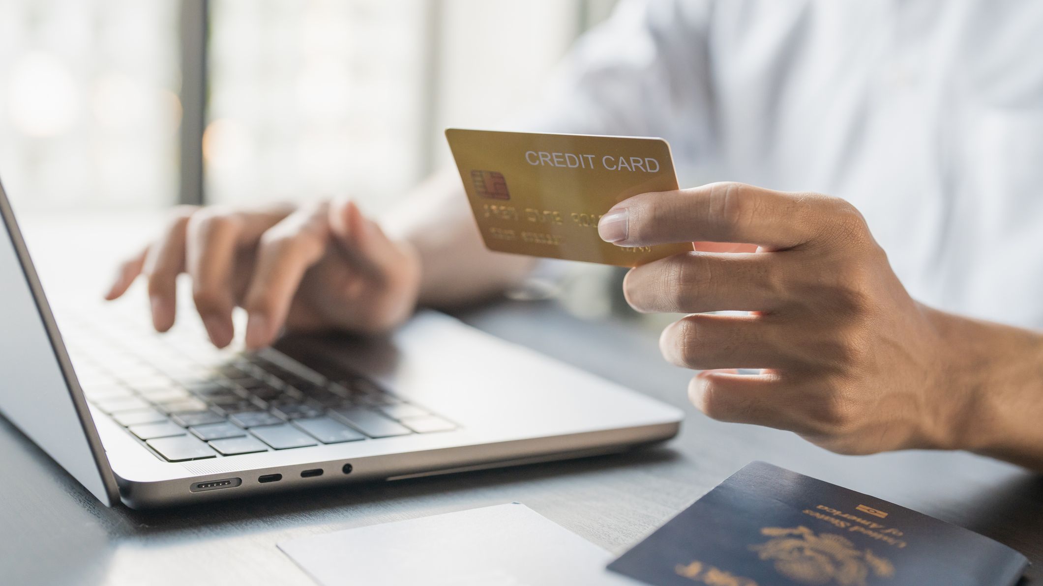 Man Online booking and buying plane tickets using laptop phone and credit card