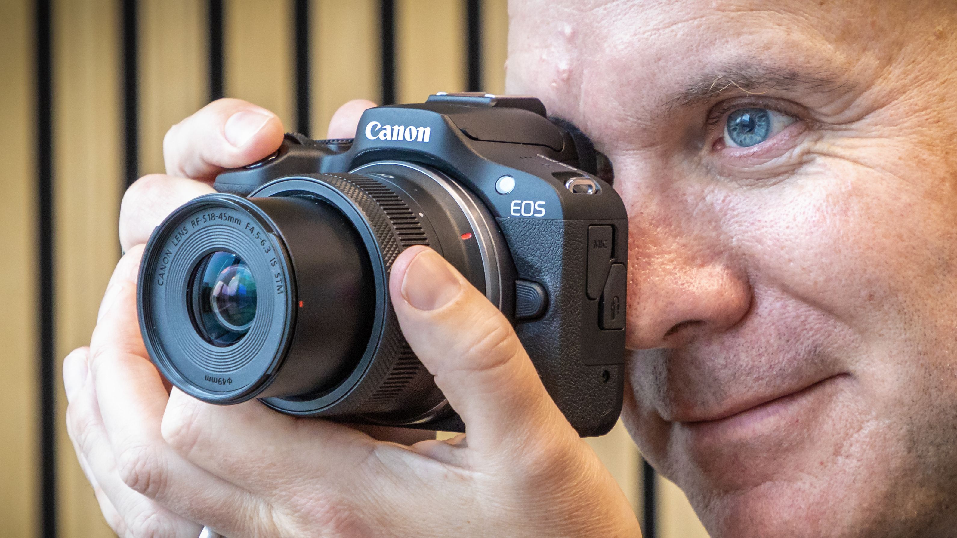 Peter Travers holding the Canon EOS R100 camera