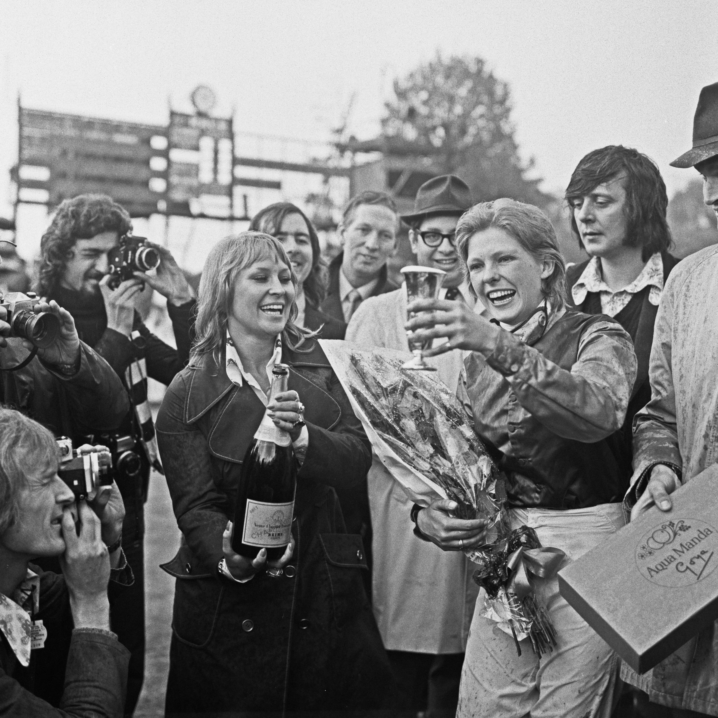 Femal jockey Meriel Tufnell is presented with a cup after winning a horse race