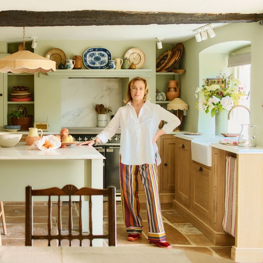 Penelope Chilvers in her kitchen and her cabinets which are hand painted with butterflies