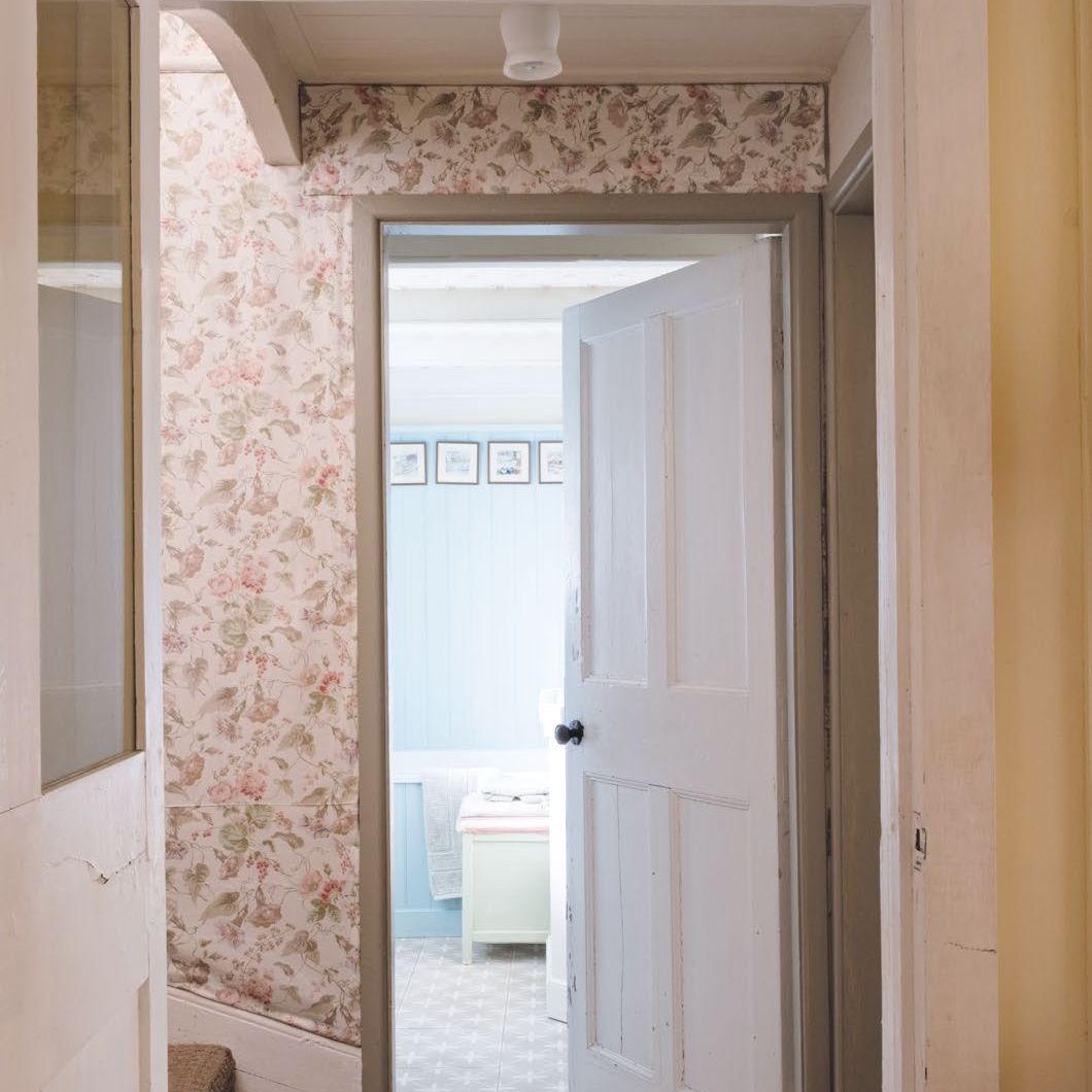 Small cottage hallway with the walls decorated with a vintage floral fabric