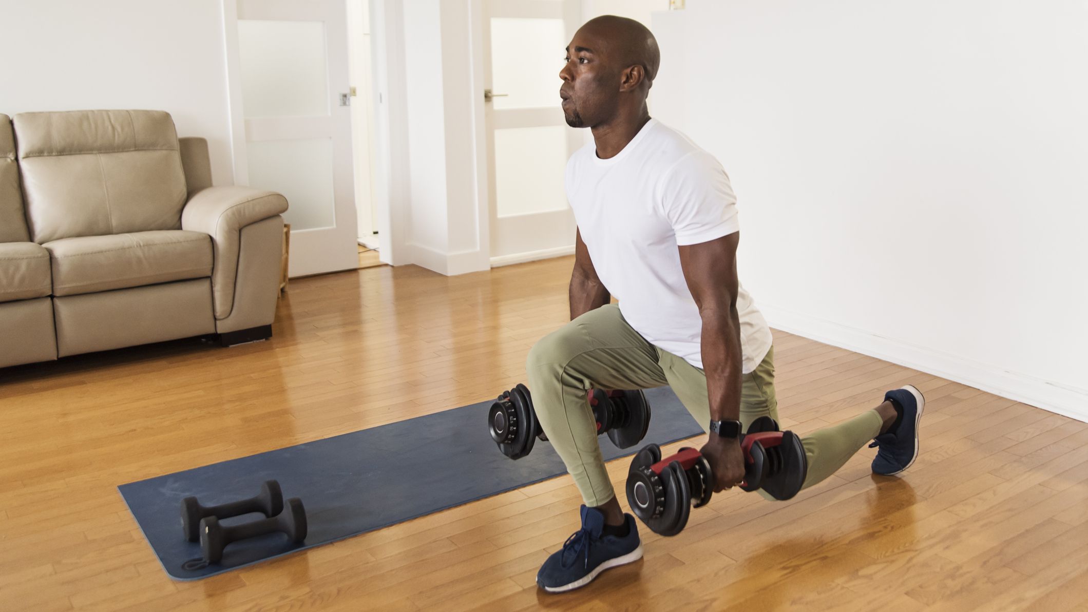 Man exercising with dumbbells in domestic setting