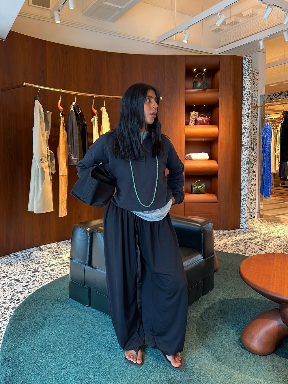 Monikh Dale wears a navy Henley jumper with navy balloon trousers and strappy heeled sandals