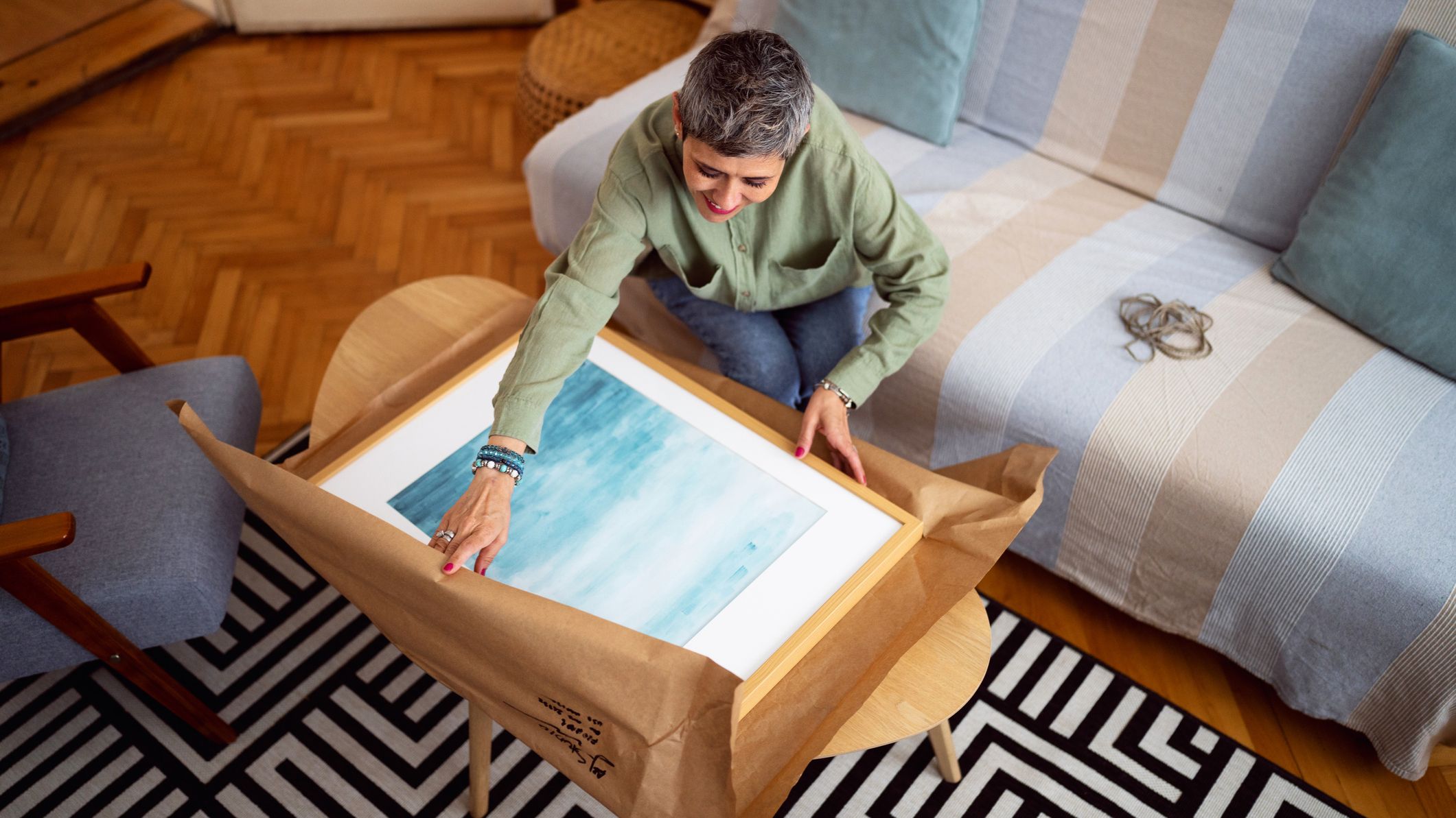 A woman unwrapping a new piece of art.