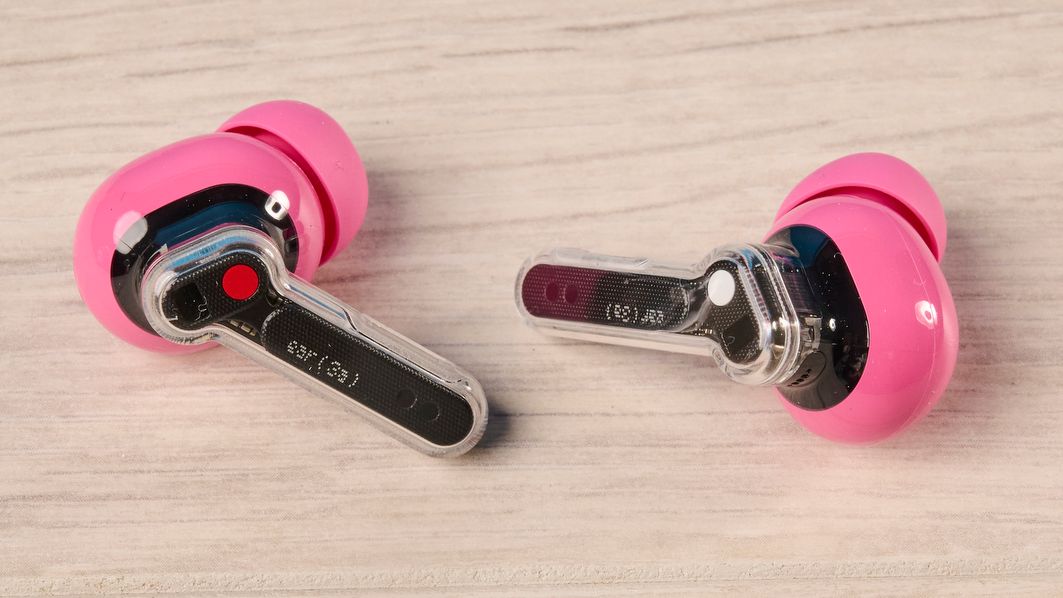 The Nothing Earbuds (3a) in pink, on a wooden surface