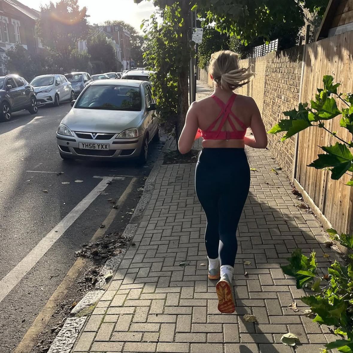 Fitness journalist Alice Porter runs along a street in the evening.