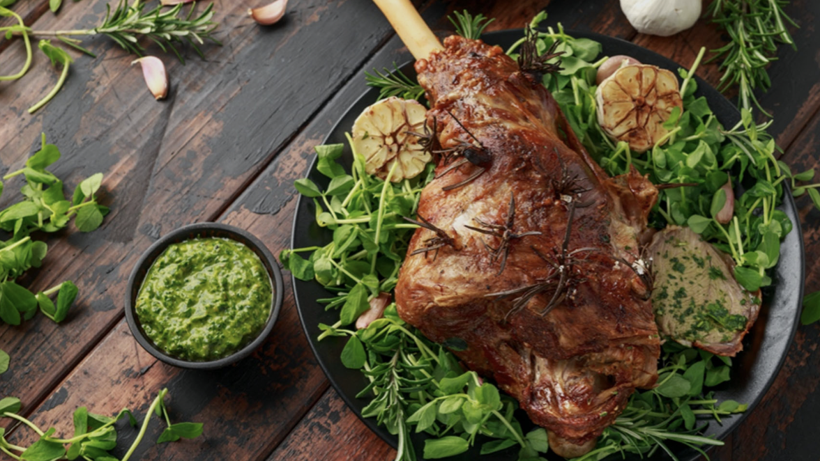 an image of one of the dishes on offer at Aktar, showing a leg of lamb on a bed of green leaves