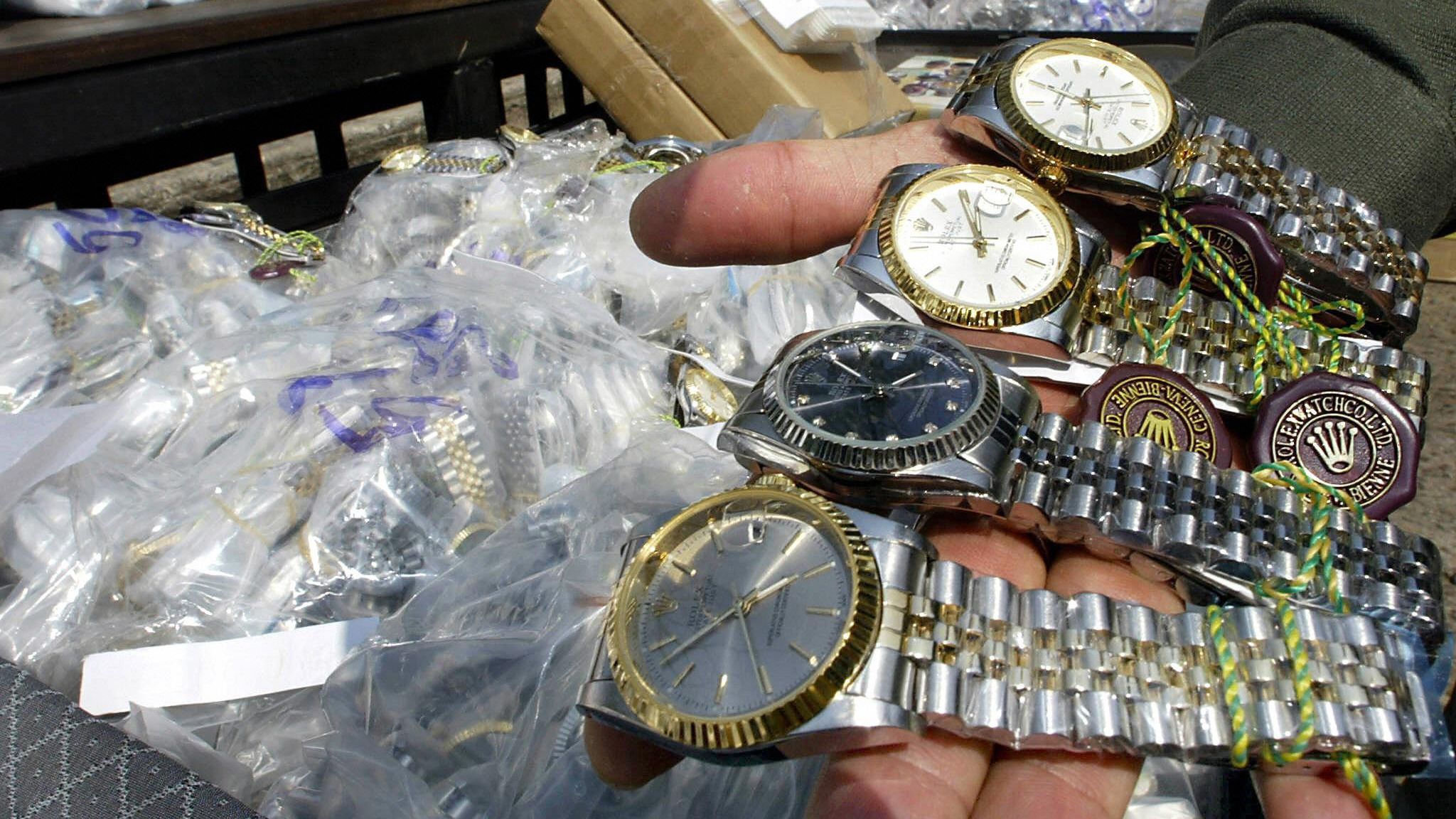 BANGKOK, THAILAND: An unidentified Thai customs officer shows counterfeit Rolex watches confiscated in different raids during a display at the customs house in Bangkok, 11 March 2004. Thai authorities displayed different counterfeit items smuggled into the kingdom from overseas to show Thailand&amp;amp;apos;s commitment to halting the proliferation of fake goods and violations of intellectual property.