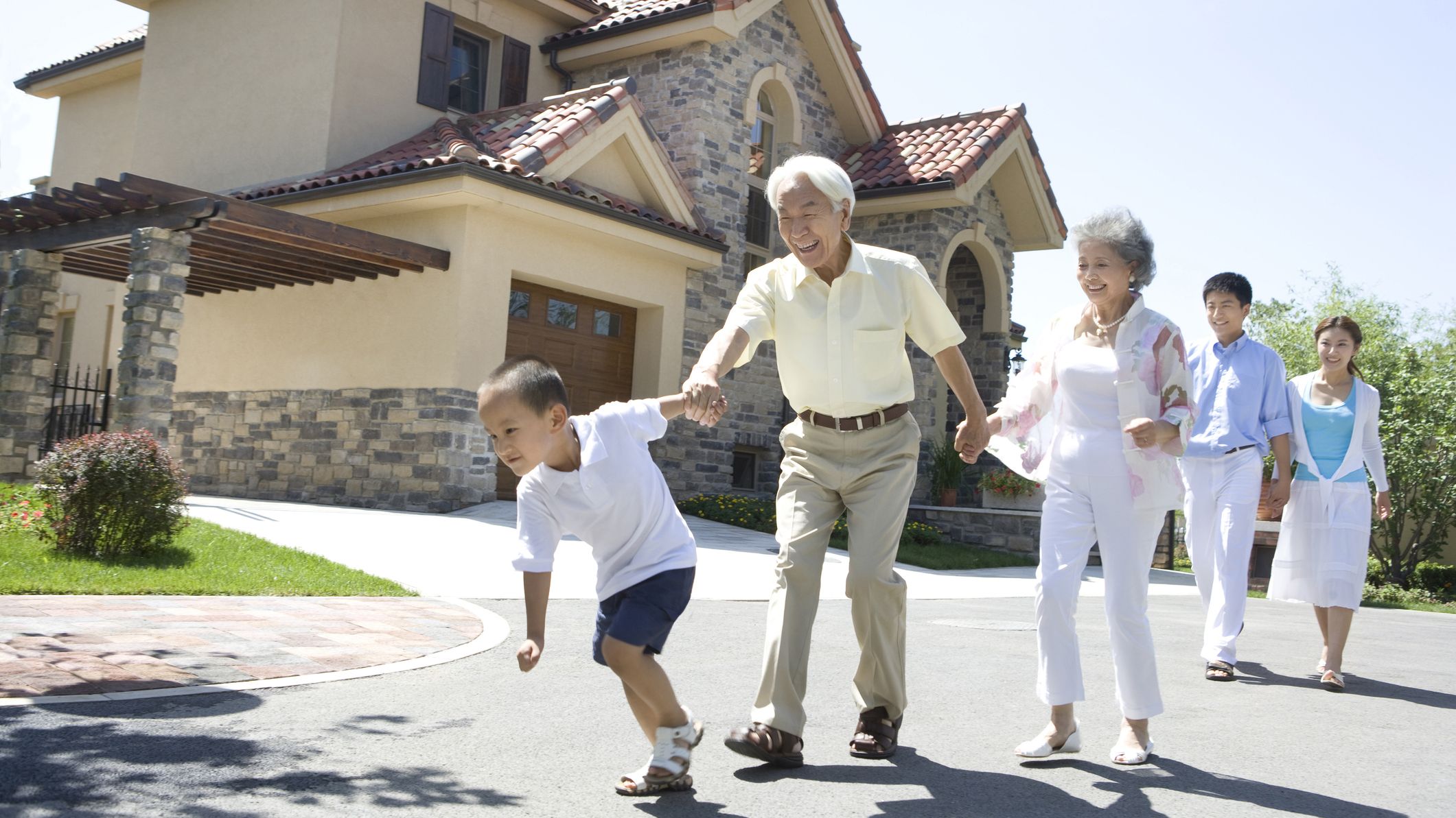 Three generation family walking by a house