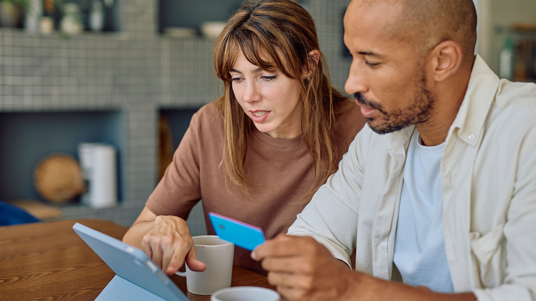 Focused couple using digital tablet and credit card