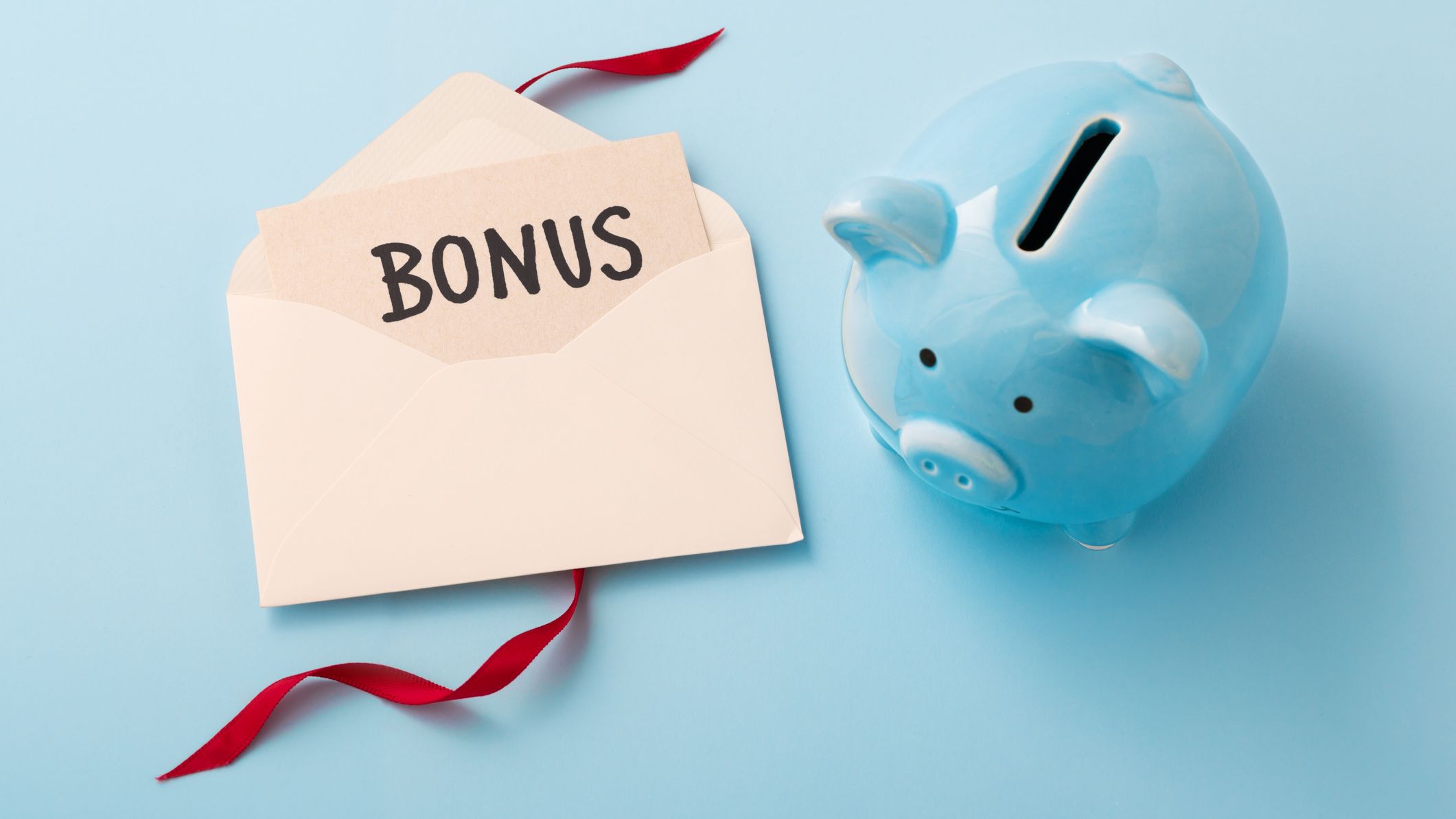 Bonus card in envelope with red ribbon and piggy bank on blue background