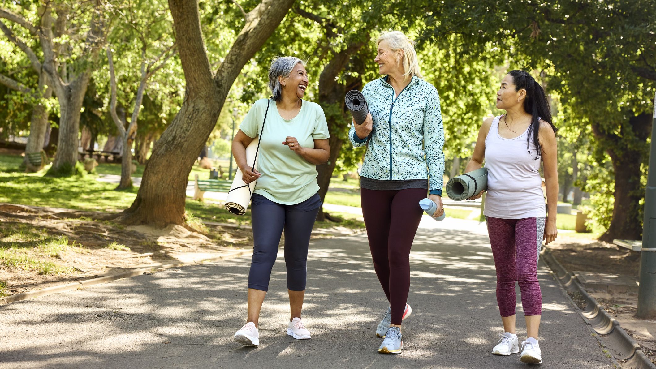 Happy woman talking with friends while walking on road.