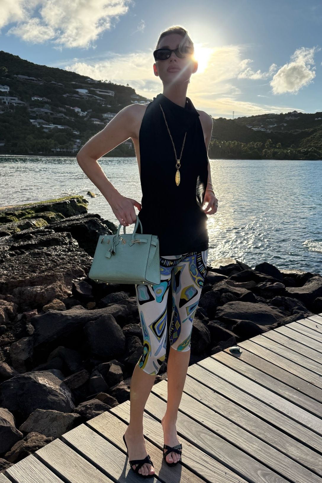 Fashion person and model Elsa Hosk wears a winter sun outfit. She wears Pucci capri leggings a black halter neck top, black strappy heels and teal blue birkin.