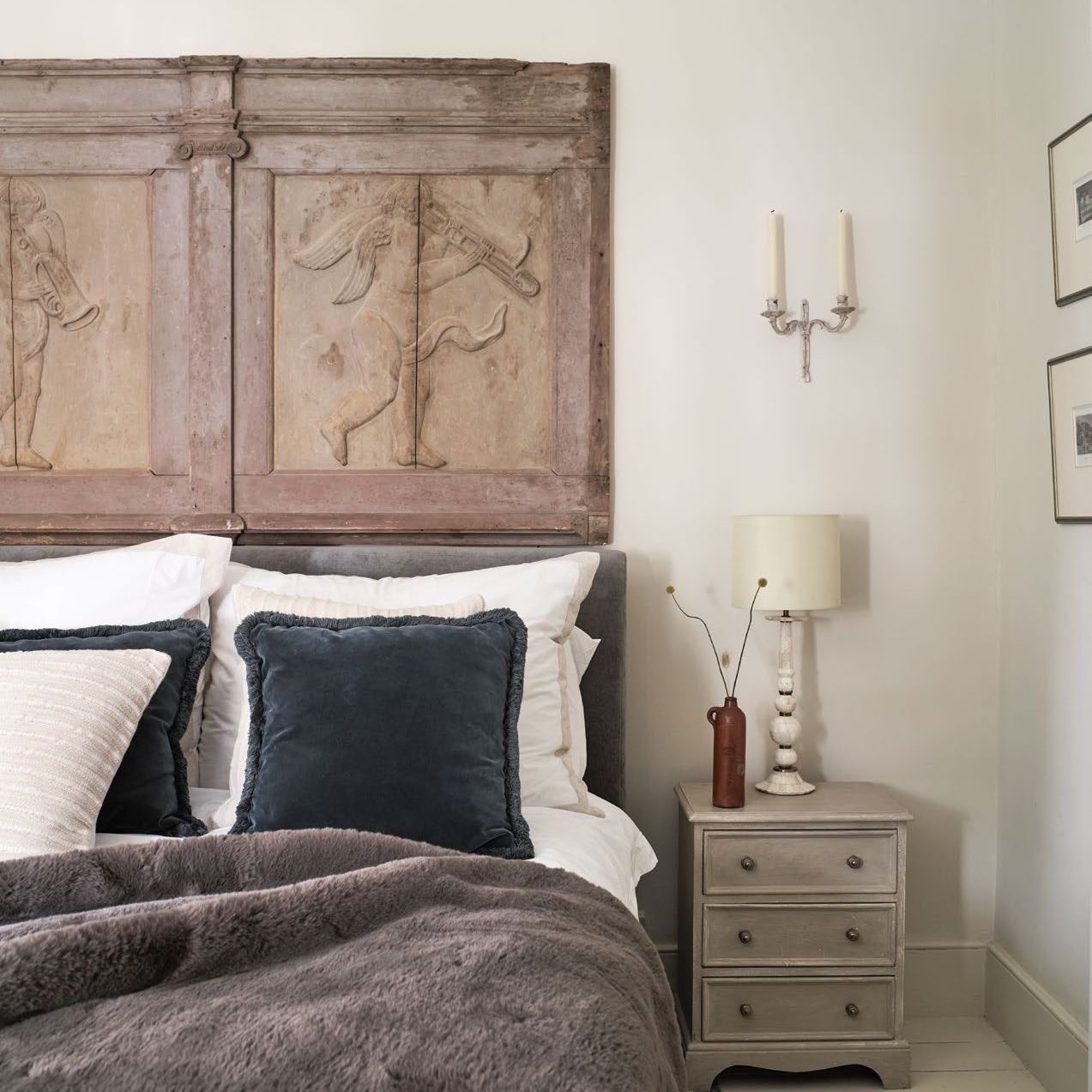 bedroom with neutral decor, antique wooden wall frieze and painted floorboards
