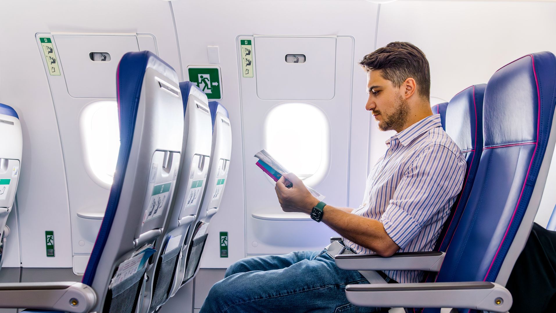Man reading inflight magazine in the airplane during the flight