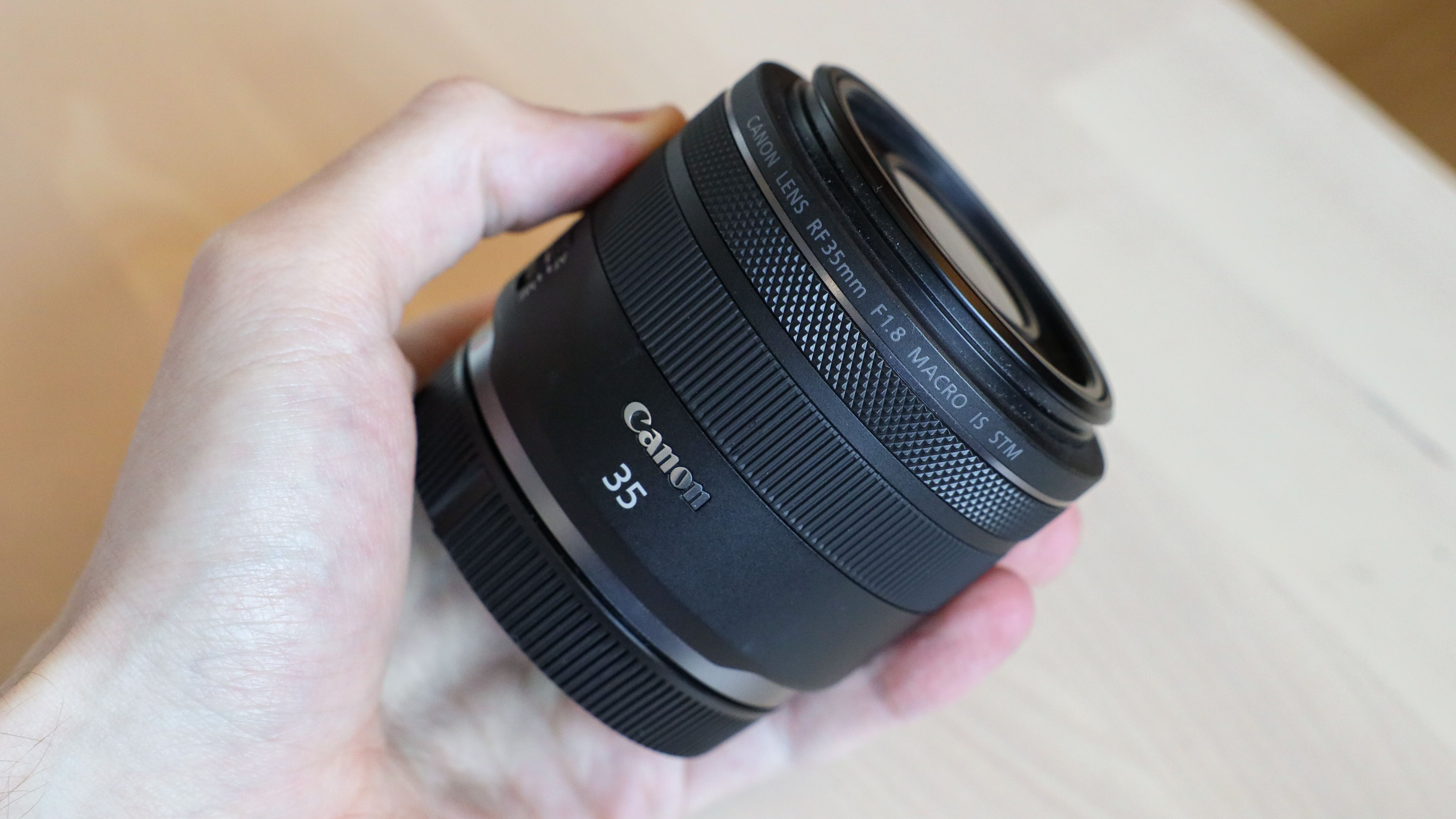 Canon RF 35mm f/1.8 Macro IS STM being held in the hand of one of our experts
