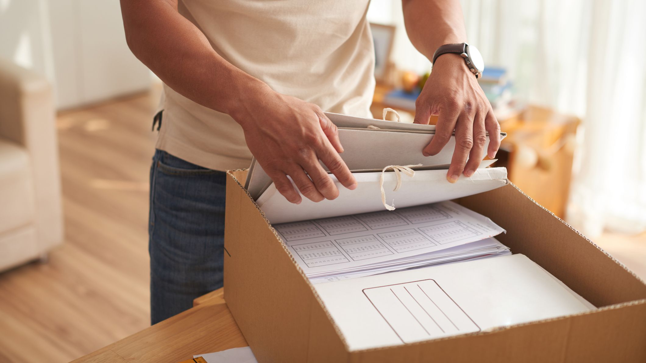 Young Man Sorting Box of Documents