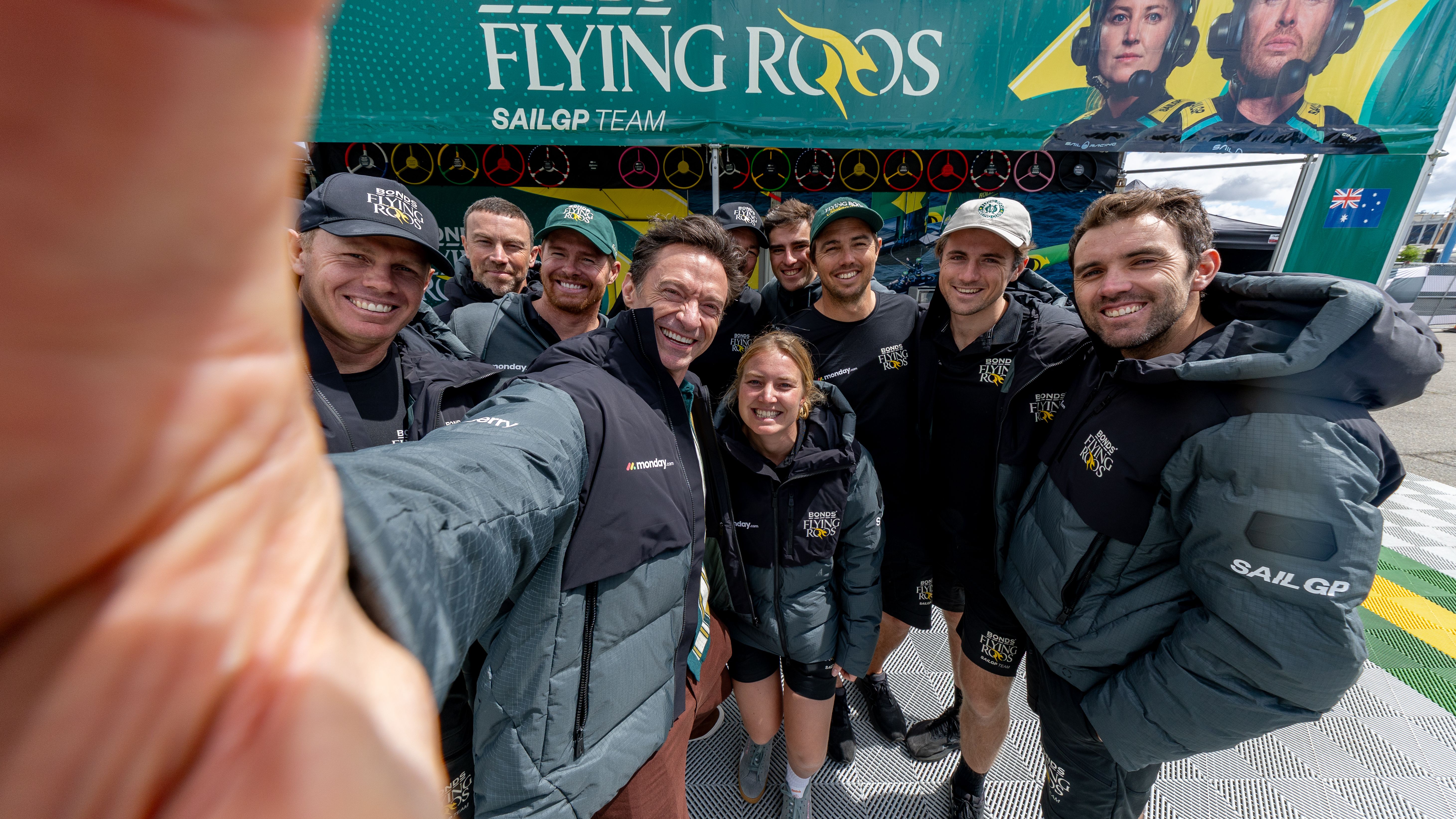 Hugh Jackman, co-owner of BONDS Flying Roos SailGP Team, takes a selfie with the BONDS Flying Roos SailGP Team in the technical area on Race Day 1 of the Mubadala New York Sail Grand Prix. Rolex SailGP Championship Event 6