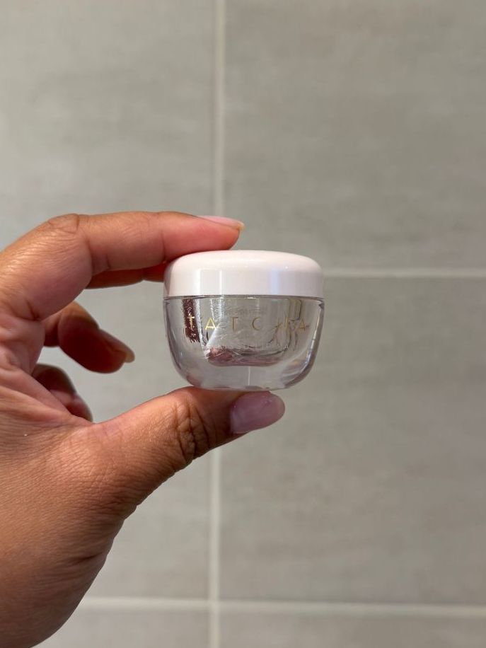 Aleesha holding empty Tatcha Kissu Lip Balm