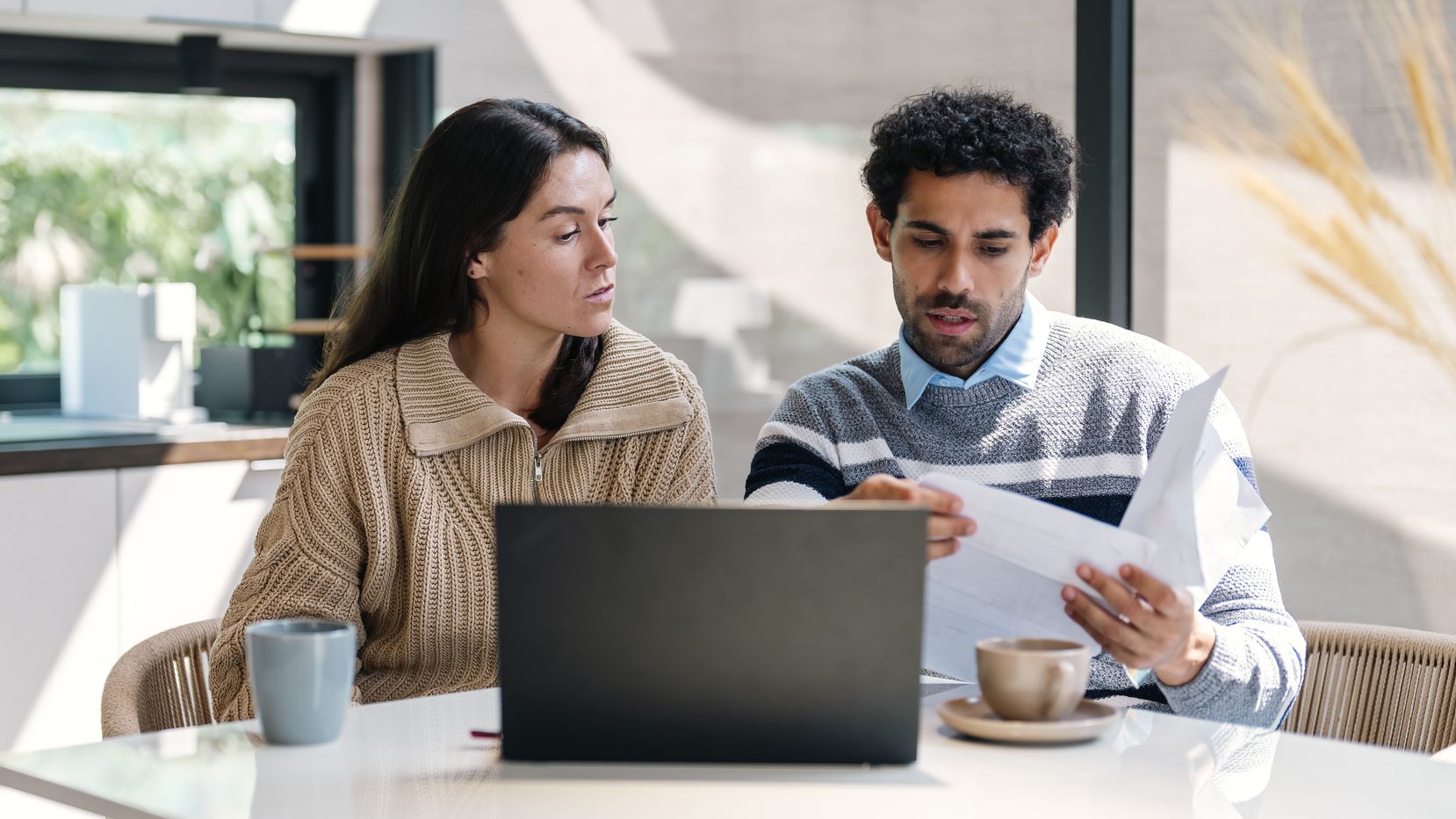 a couple going over their finances at a kitchen table