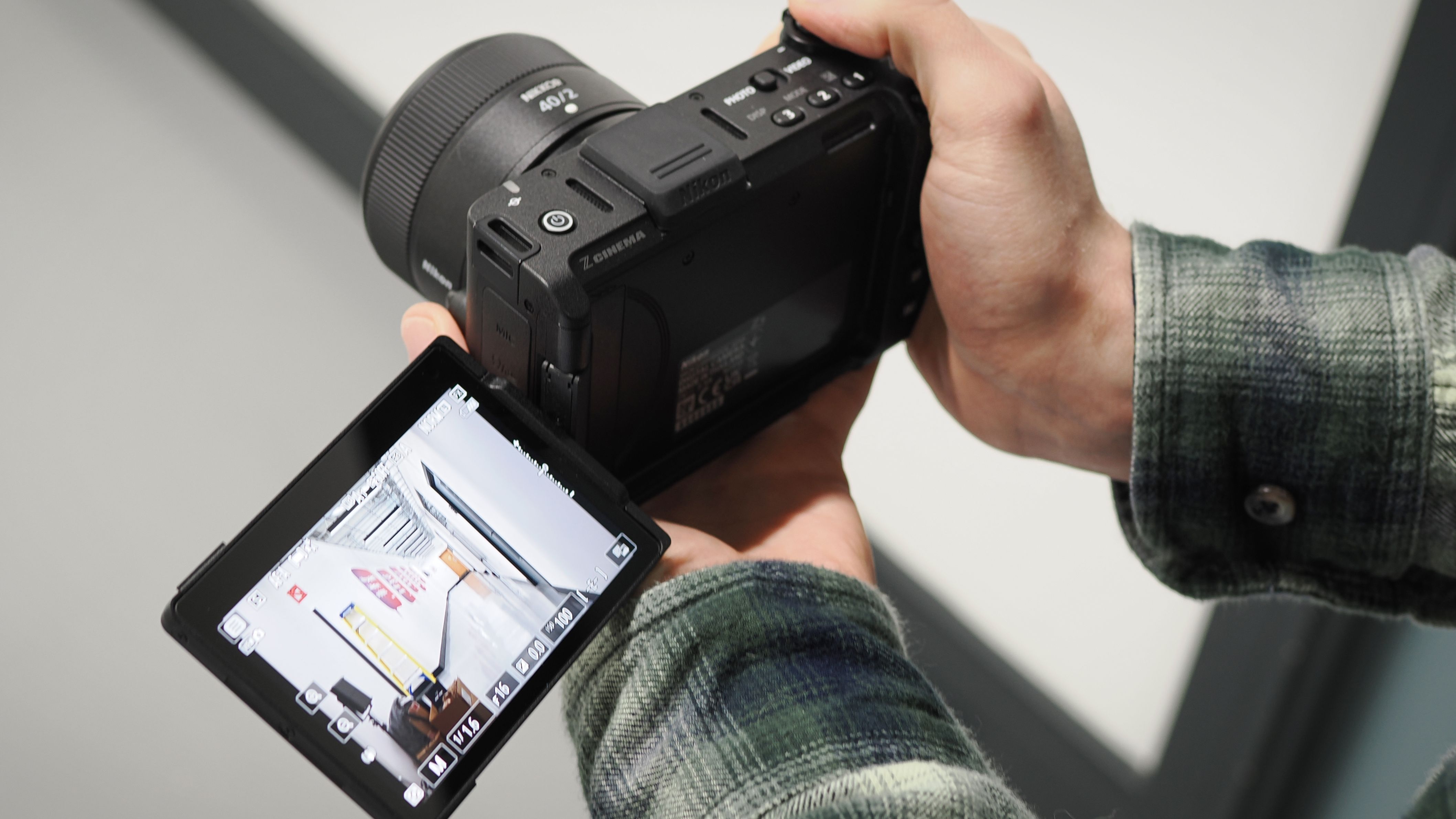 Mike Harris holding a Nikon ZR with 40mm lens in an office building