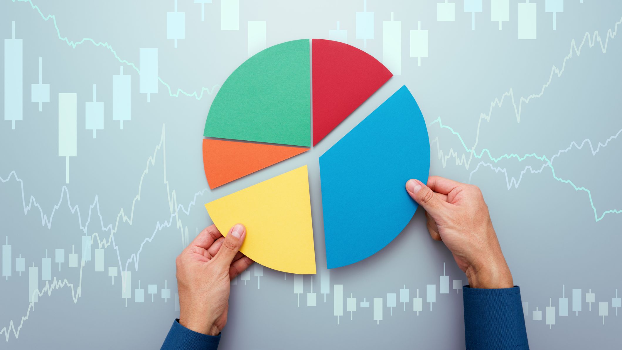 Strategy of diversified investment. Investor managing portfolio. Pie chart and candlestick charts.