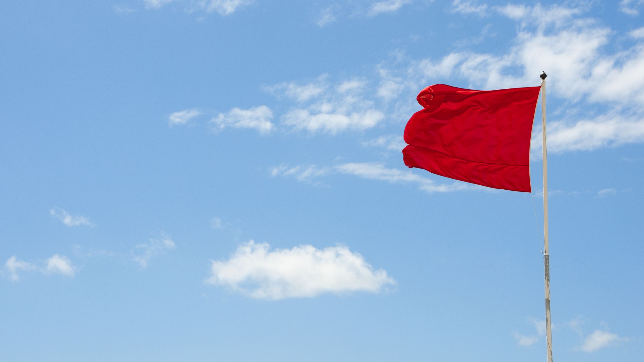Red flag warning of danger against a blue sky