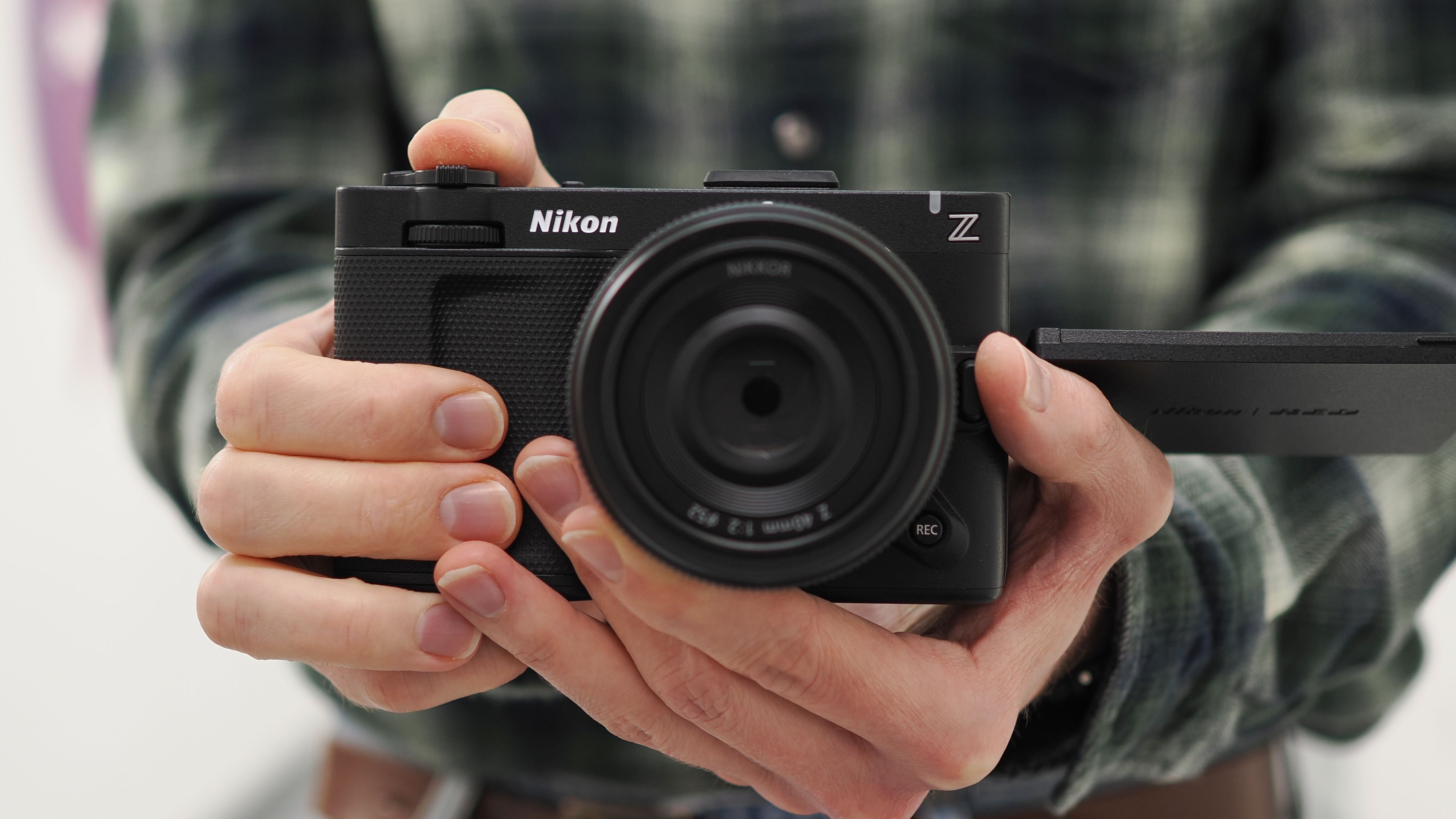Mike Harris holding a Nikon ZR with 40mm lens in an office building