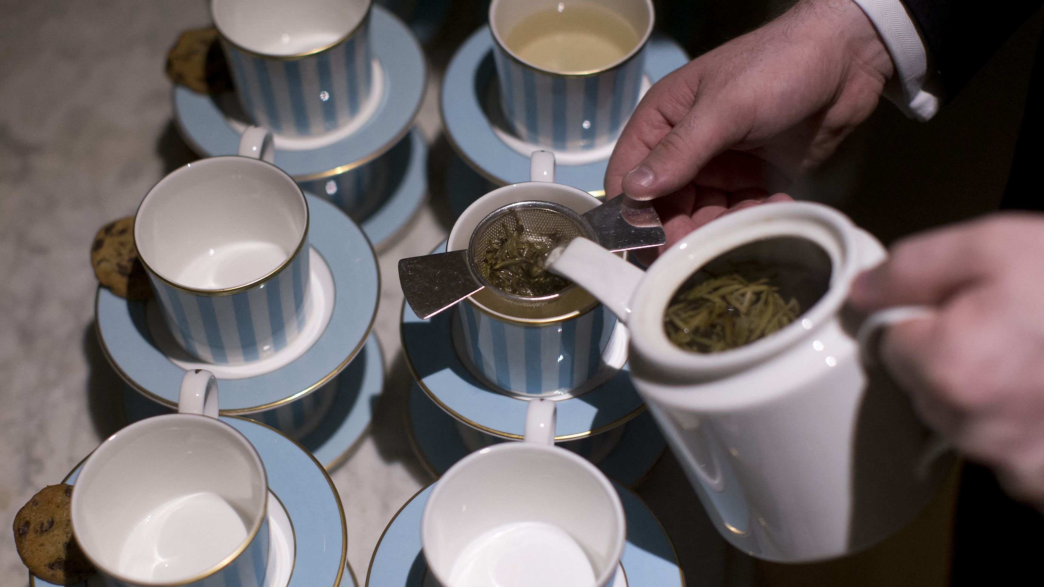 A member of hotel staff pours cups of tea at the Kensington Hotel in London on August 11, 2016. The popularity of afternoon tea has London hotels vying to attract a new wave of customers by inventing twists on the classic English indulgence -- although with tapas and takeaways on offer, some say the trend is going too far. (Photo by JUSTIN TALLIS / AFP) / TO GO WITH AFP STORY BY ROBIN MILLARD (Photo by JUSTIN TALLIS/AFP via Getty Images)